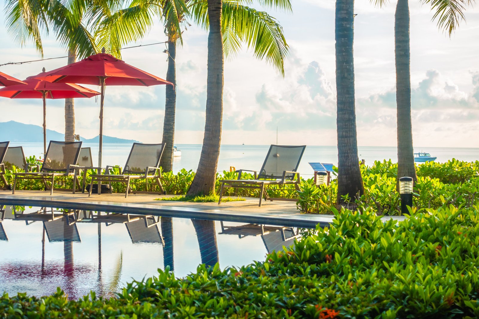 Beautiful luxury outdoor swimming pool with umbrella and chair in hotel and resort for travel and vacation